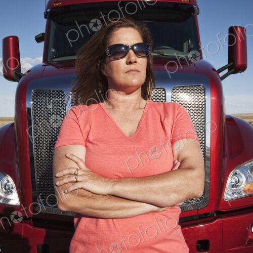 Portrait of a Caucasian woman driver and her commercial truck. Portrait of a Caucasian woman driver and her commercial truck.