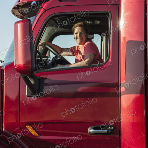 Portrait of a Caucasian woman driver and her commercial truck. Portrait of a Caucasian woman driver and her commercial truck.