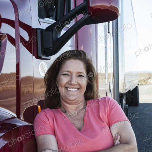 Portrait of a Caucasian woman driver and her commercial truck. Portrait of a Caucasian woman driver and her commercial truck.