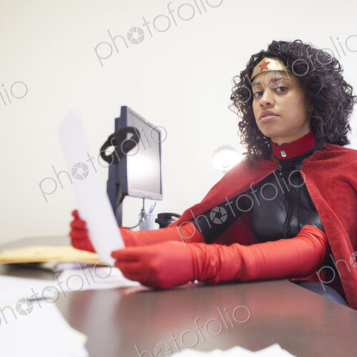 Portrait of a black businesswoman office super hero sitting at her office computer. Portrait of a black businesswoman office super hero sitting at her office computer.