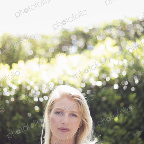 Portrait of a blond woman standing in a garden. Portrait of a blond woman standing in a garden.