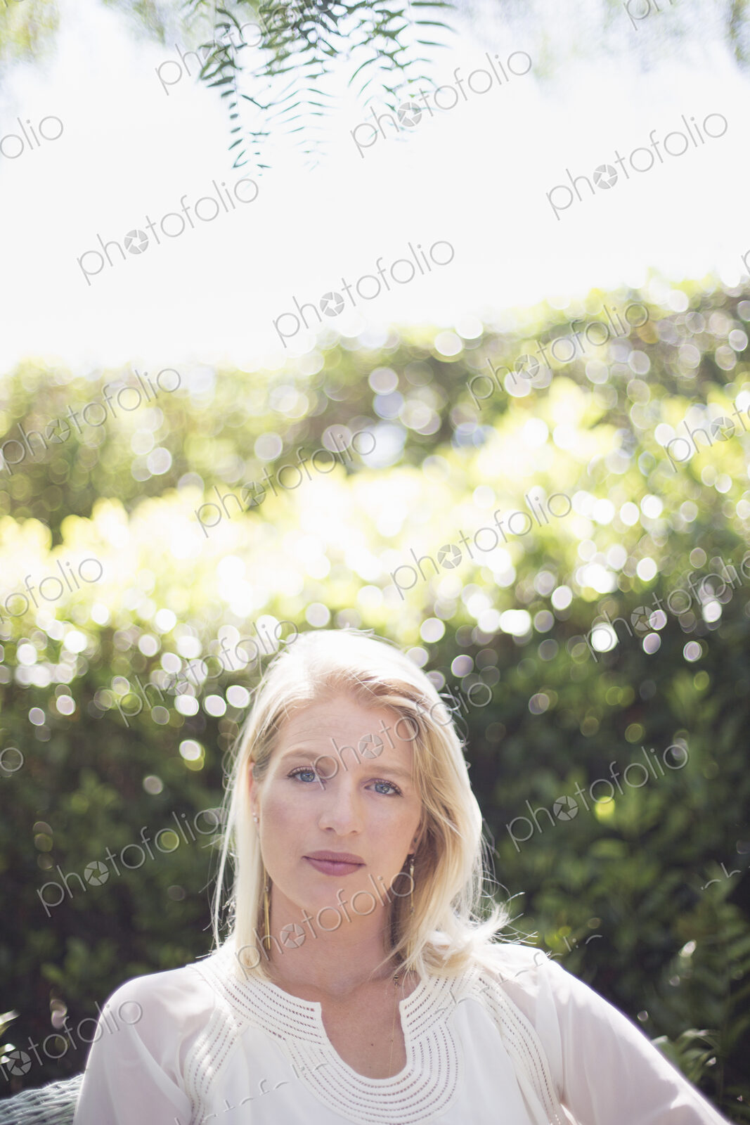 Portrait of a blond woman standing in a garden.