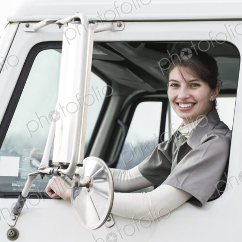 Portrait of a caucasian female truck driver in the window of her truck at a… Portrait of a caucasian female truck driver in the window of her truck at a…