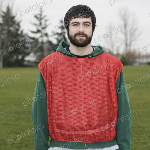Portrait of a caucasian man playing outdoor sports, wearing a red team vest, hands in… Portrait of a caucasian man playing outdoor sports, wearing a red team vest, hands in…