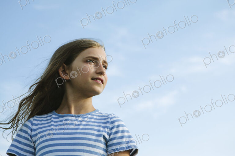Portrait of a confident and happy nine year old girl outdoors.