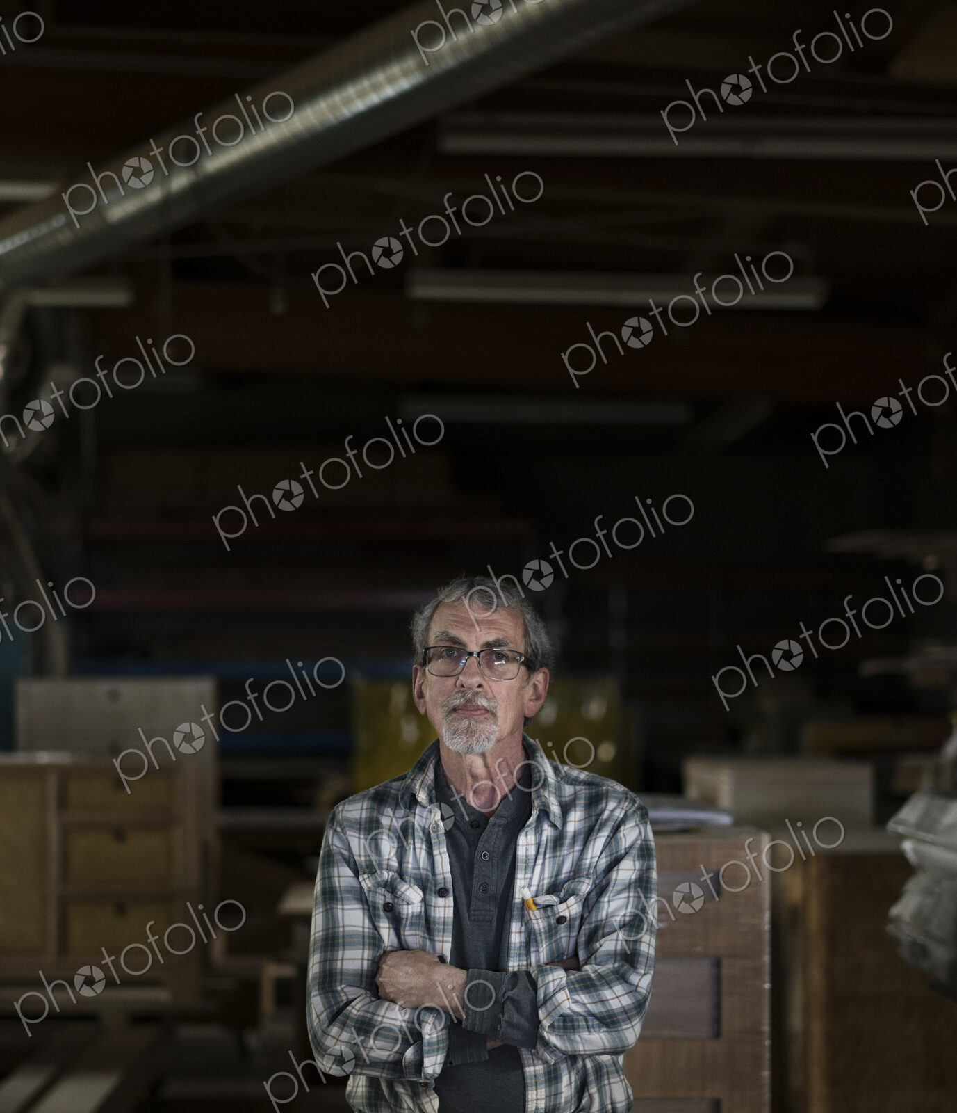 Portrait of a senior Caucasian carpenter in a large woodworking shoop.