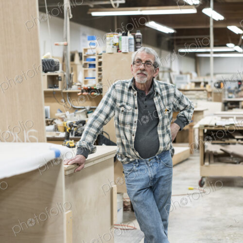 Portrait of a senior Caucasian carpenter in a large woodworking shoop.