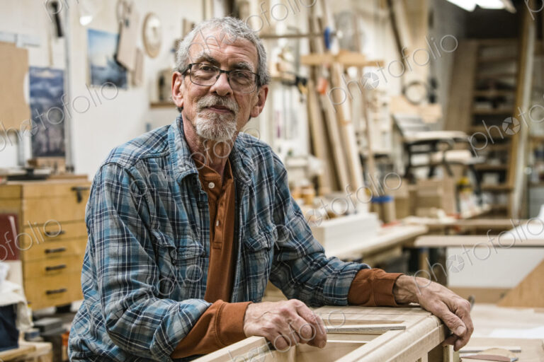 Portrait of a senior Caucasian carpenter in a large woodworking shoop.