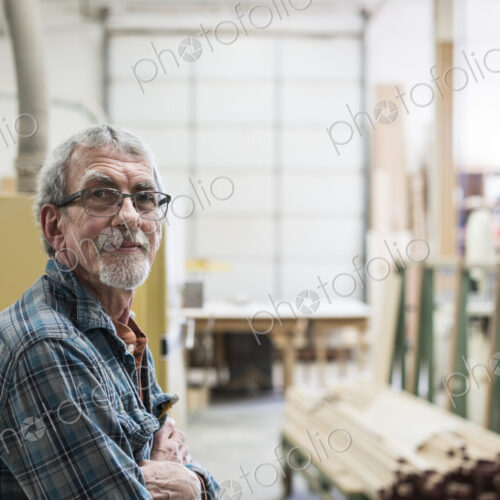 Portrait of a senior Caucasian carpenter in a large woodworking shop. Portrait of a senior Caucasian carpenter in a large woodworking shop.