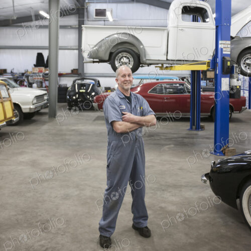 Portrait of a senior caucasian male owner of an antique car repair shop