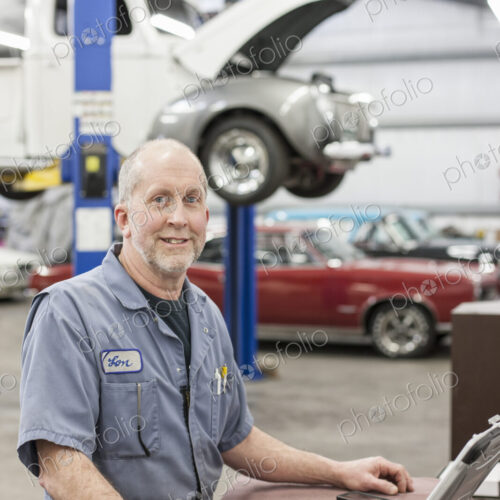 Portrait of a senior caucasian male owner of an antique car repair shop