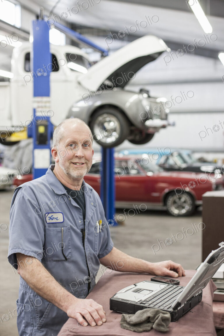 Portrait of a senior caucasian male owner of an antique car repair shop