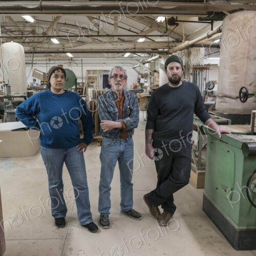 Portrait of a team of three mixed race carpenters in a large woodworking factory.