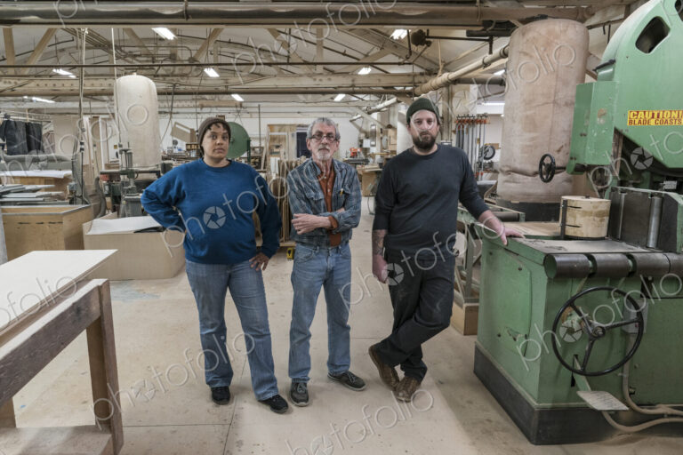 Portrait of a team of three mixed race carpenters in a large woodworking factory.