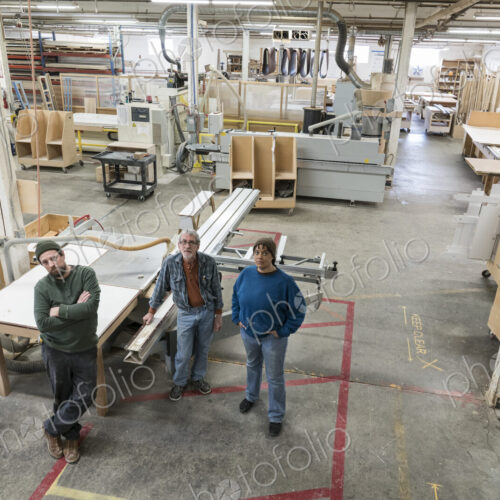 Portrait of a team of three mixed race carpenters in a large woodworking factory.