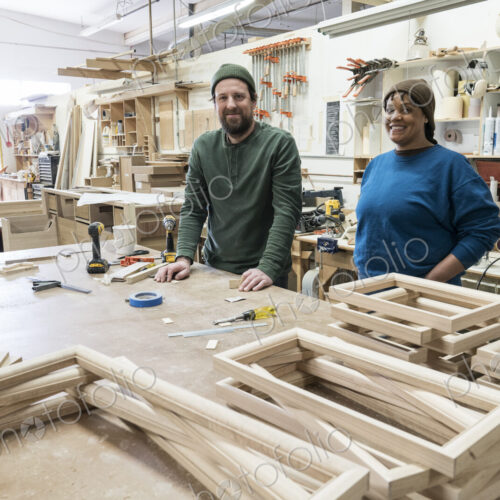 Portrait of a team of two mixed race male and female carpenters in a large woodworking… Portrait of a team of two mixed race male and female carpenters in a large woodworking…