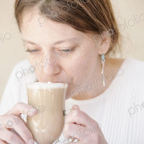 Portrait of a woman with auburn hair drinking a cafe latte. Portrait of a woman with auburn hair drinking a cafe latte.