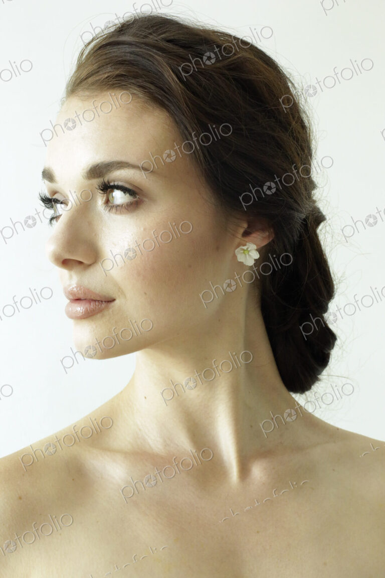 Portrait of a woman with brown hair tied in an elegant bun.
