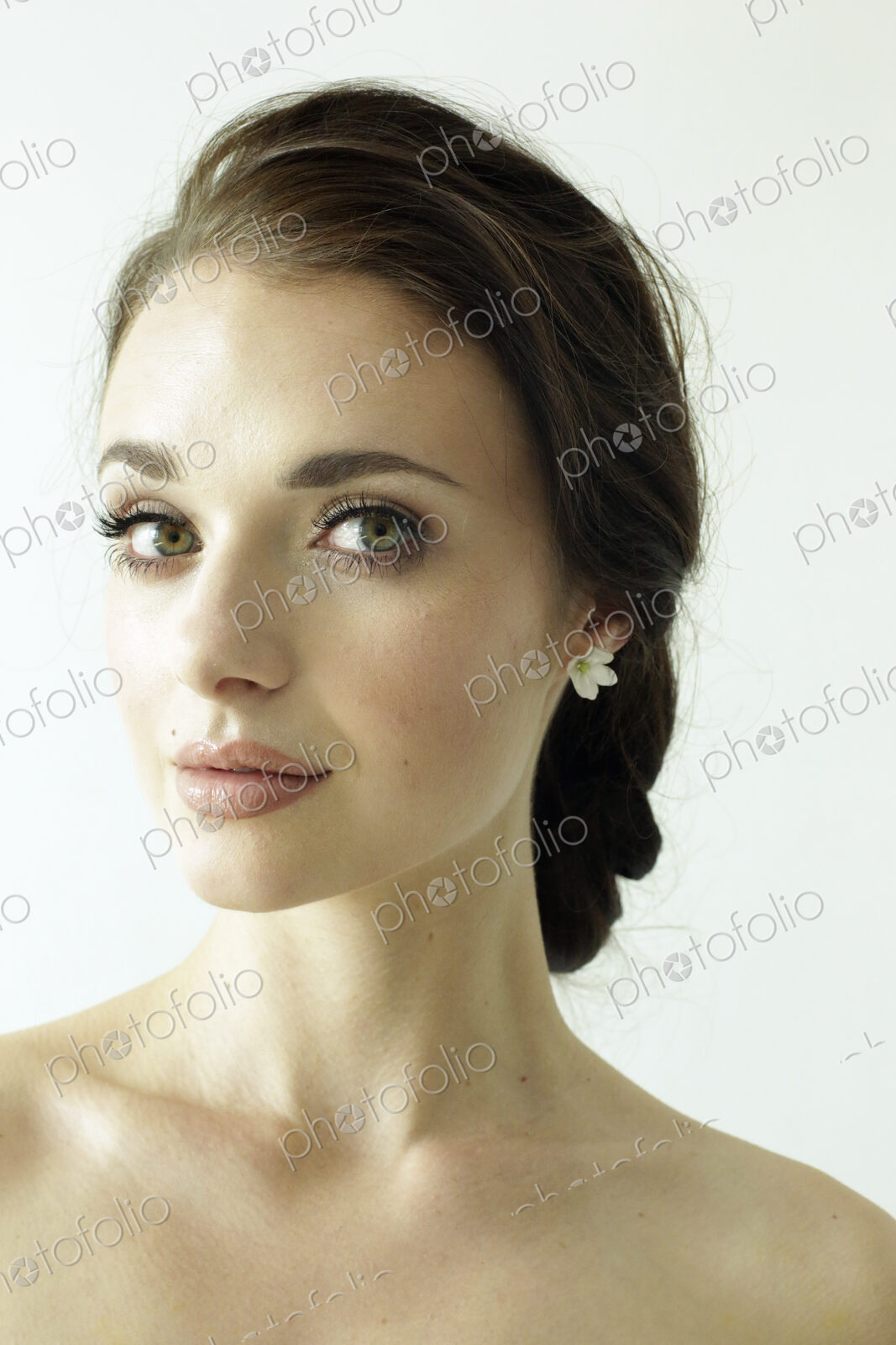 Portrait of a woman with brown hair tied in an elegant bun.