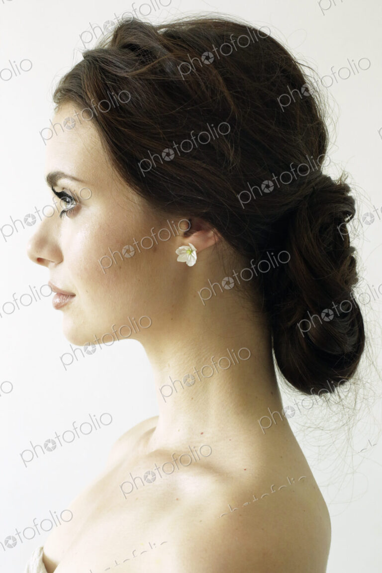Portrait of a woman with brown hair tied in an elegant bun.