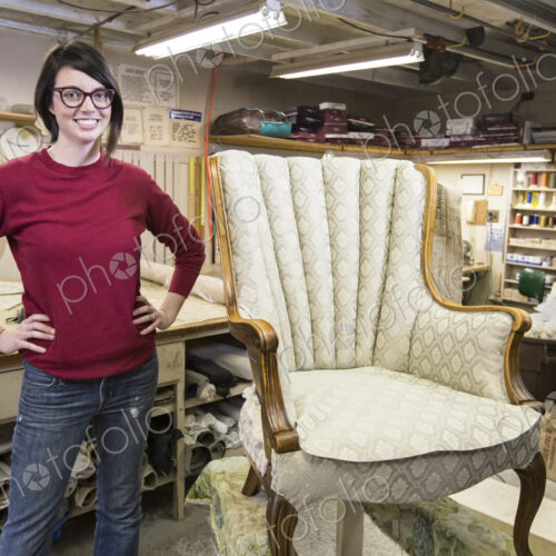 Portrait of a youg Caucasian woman upholsterer and a chair she is working on. Portrait of a youg Caucasian woman upholsterer and a chair she is working on.
