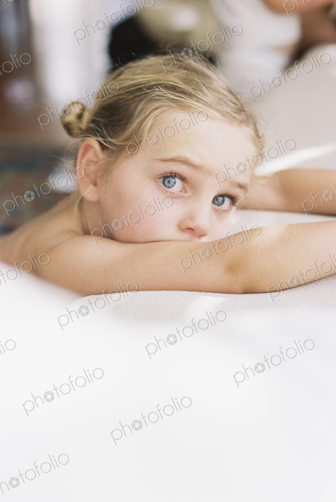 Portrait of a young girl with blond hair, looking at camera.
