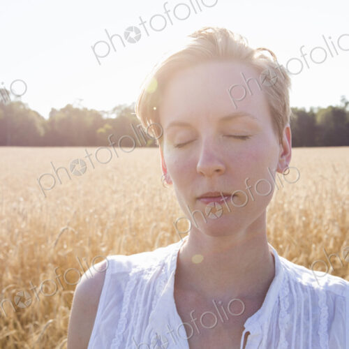 Portrait of a young woman standing in a cornfield. Portrait of a young woman standing in a cornfield.