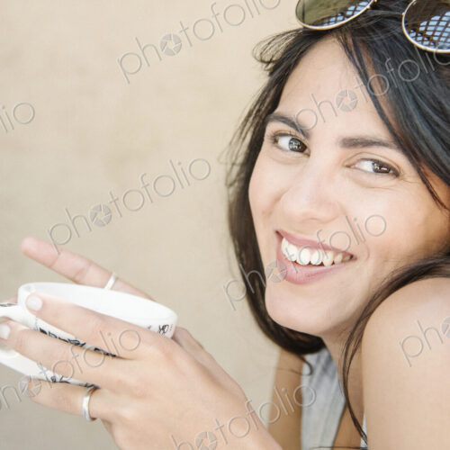 Portrait of a young woman with long brown hair holding a cup. Portrait of a young woman with long brown hair holding a cup.