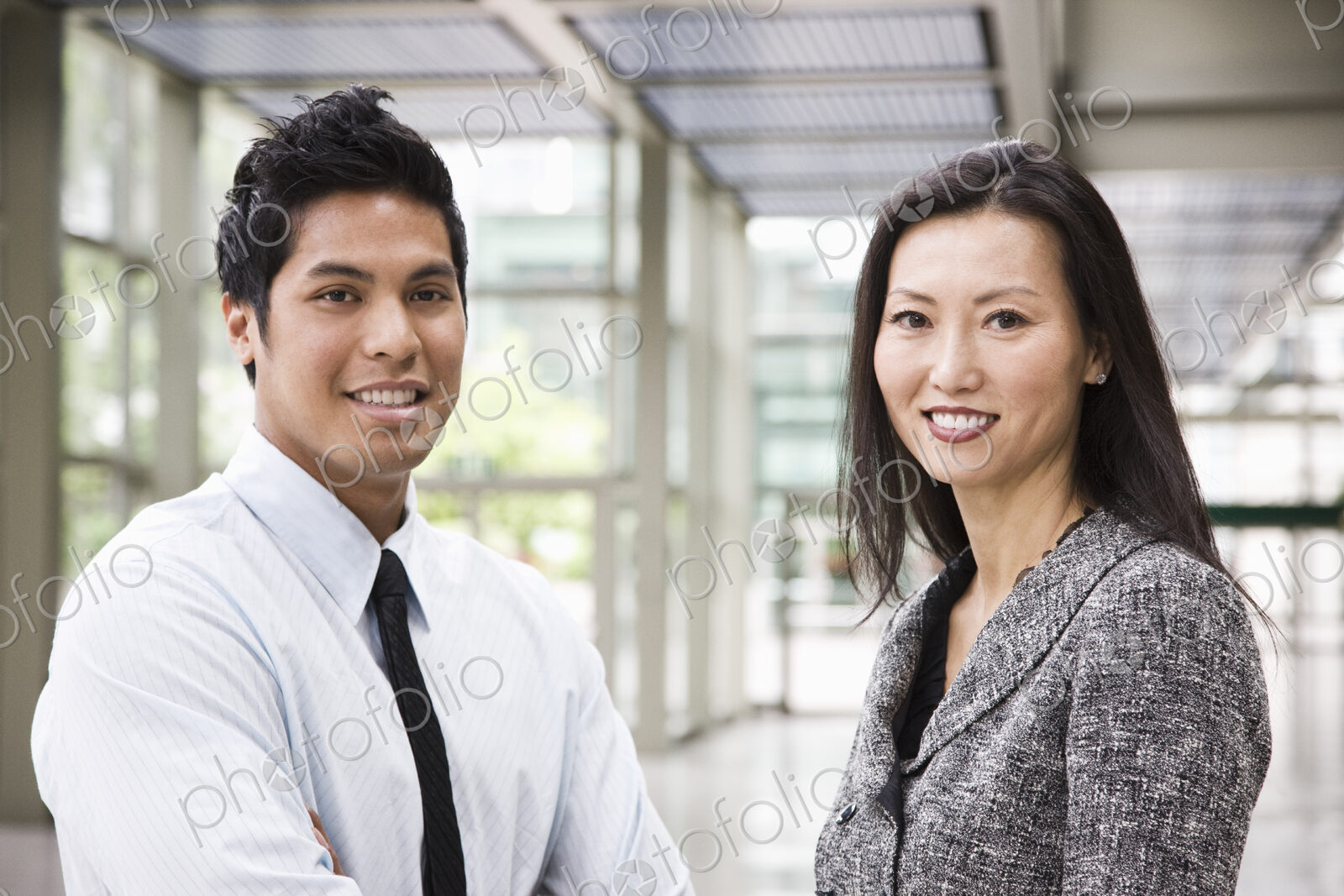 Portrait of an Asian businesswoman and a businessman in the lobby of a convention center.