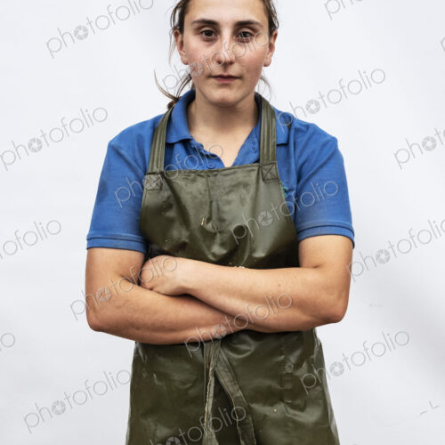 Portrait of female farmer wearing green apron looking at camera. Portrait of female farmer wearing green apron looking at camera.