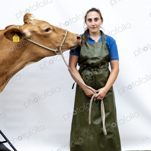 Portrait of female farmer wearing green apron with a Guernsey cow. Portrait of female farmer wearing green apron with a Guernsey cow.