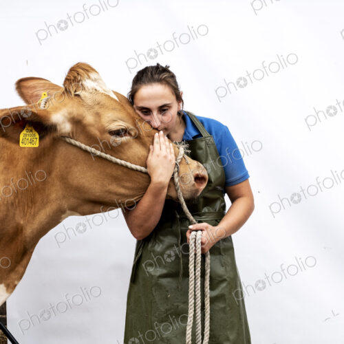 Portrait of female farmer wearing green apron with a Guernsey cow. Portrait of female farmer wearing green apron with a Guernsey cow.