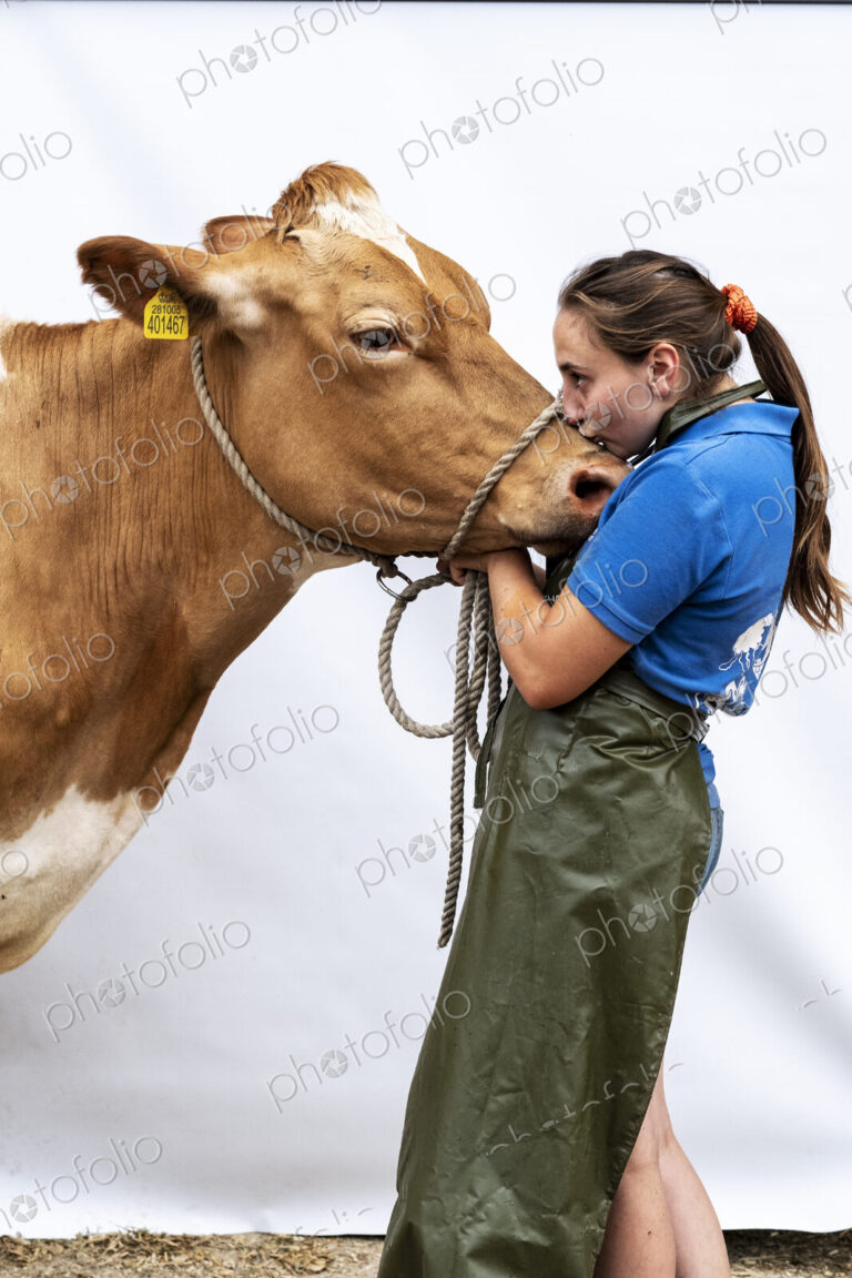 Portrait of female farmer wearing green apron with a Guernsey cow.