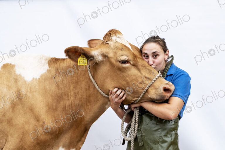 Portrait of female farmer wearing green apron with a Guernsey cow.