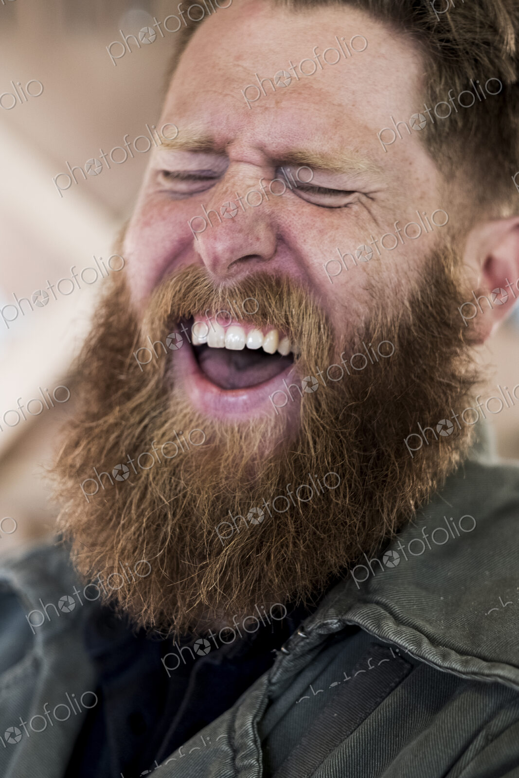 Portrait of laughing bearded man with light brown hair.