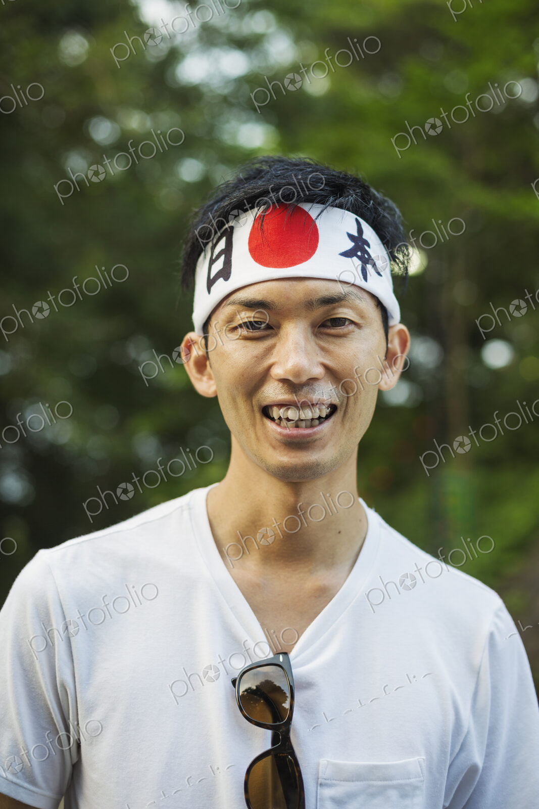 Portrait of man wearing headband with Japanese flag smiling at camera.