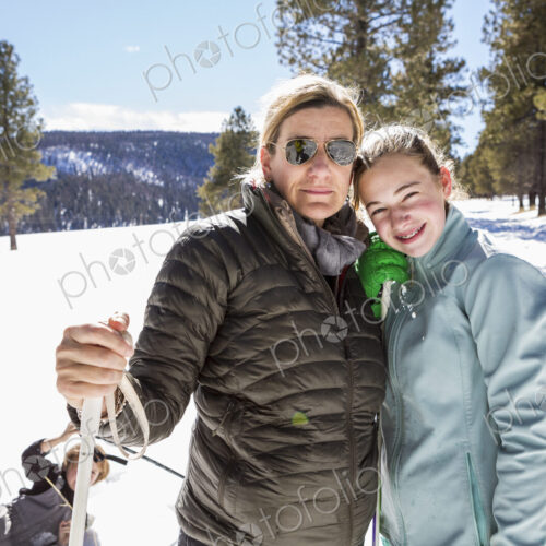 Portrait of mother and her thirteen year old daughter out in the snow.