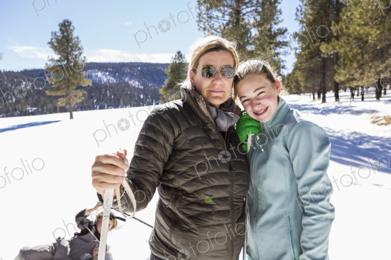 Portrait of mother and her thirteen year old daughter out in the snow.