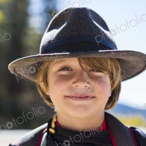 Portrait of smiling 6 year old boy with a fringe, wearing a hat