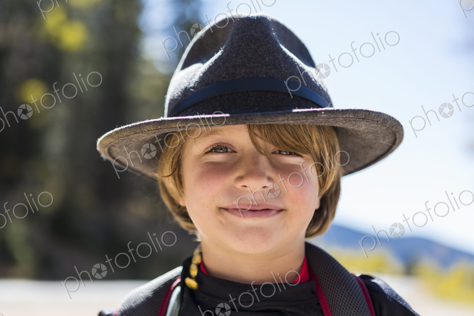 Portrait of smiling 6 year old boy with a fringe, wearing a hat