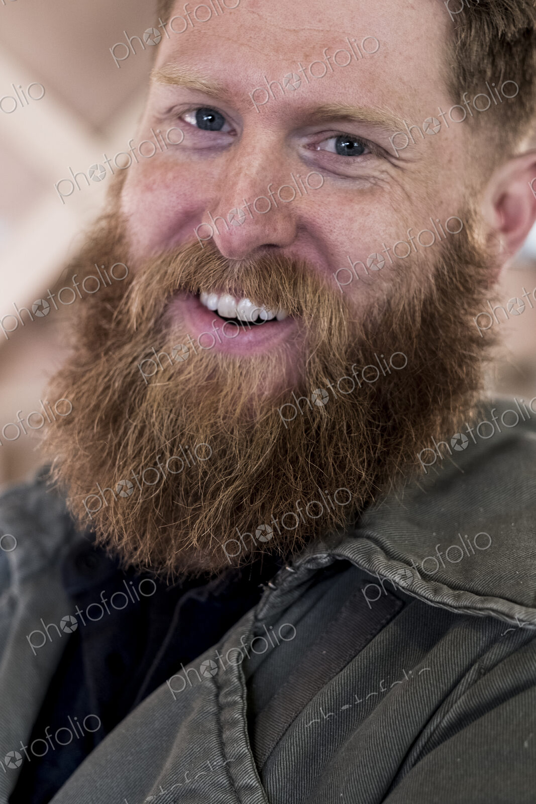 Portrait of smiling bearded man with light brown hair.