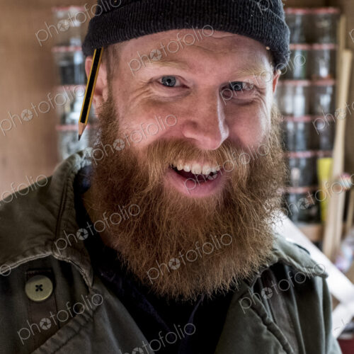 Portrait of smiling bearded man with light brown hair, wearing black beanie.