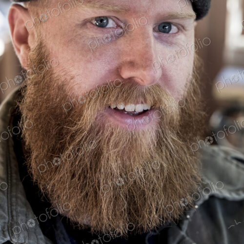 Portrait of smiling bearded man with light brown hair, wearing black beanie.