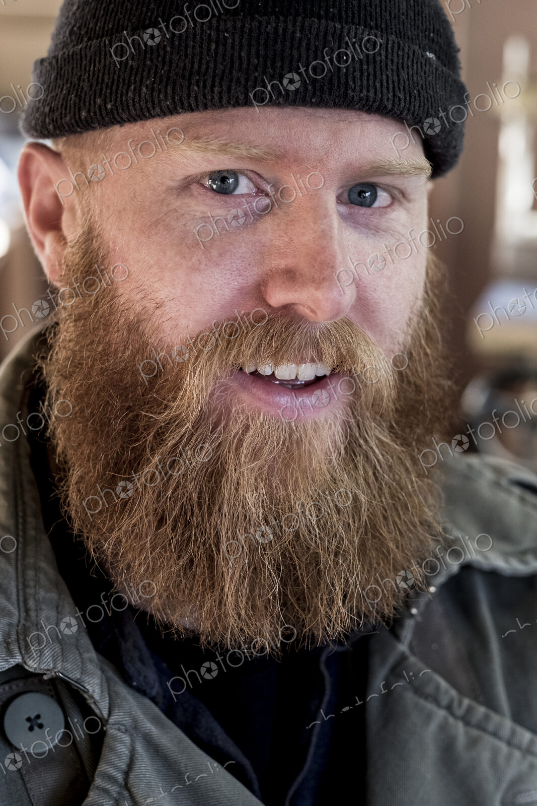 Portrait of smiling bearded man with light brown hair, wearing black beanie.