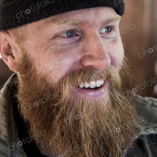 Portrait of smiling bearded man with light brown hair, wearing black beanie.