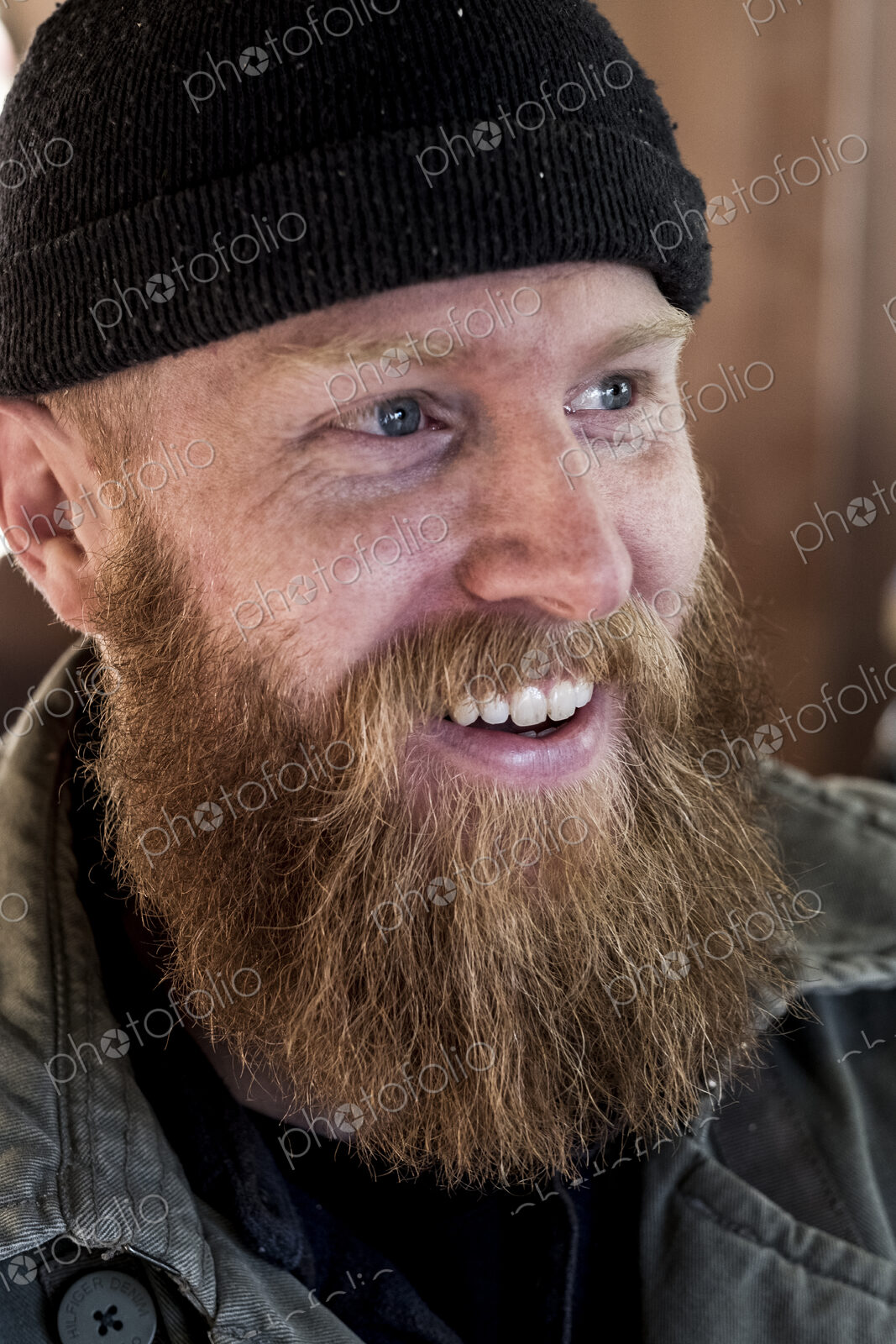 Portrait of smiling bearded man with light brown hair, wearing black beanie.