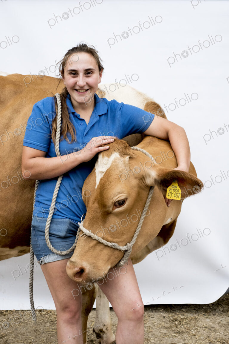 Portrait of smiling female farmer with a Guernsey cow.