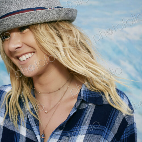 Portrait of smiling woman with long blond hair wearing blue checkered shirt and grey… Portrait of smiling woman with long blond hair wearing blue checkered shirt and grey…
