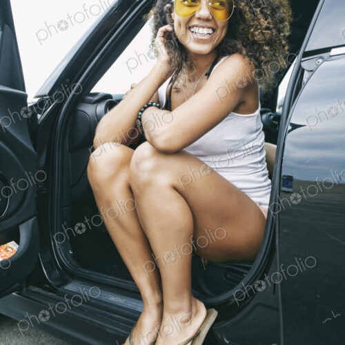 Portrait of smiling young woman wearing sunglasses, white vest and flip flops. Portrait of smiling young woman wearing sunglasses, white vest and flip flops.