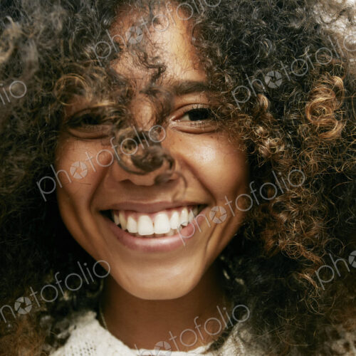 Portrait of smiling young woman with brown curly hair, looking at camera. Portrait of smiling young woman with brown curly hair, looking at camera.